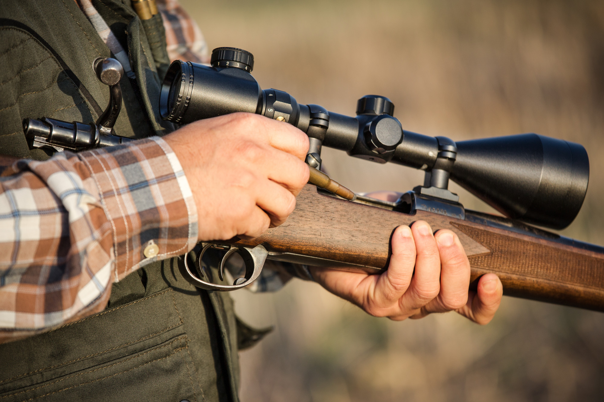 man holding a rifle with a scope